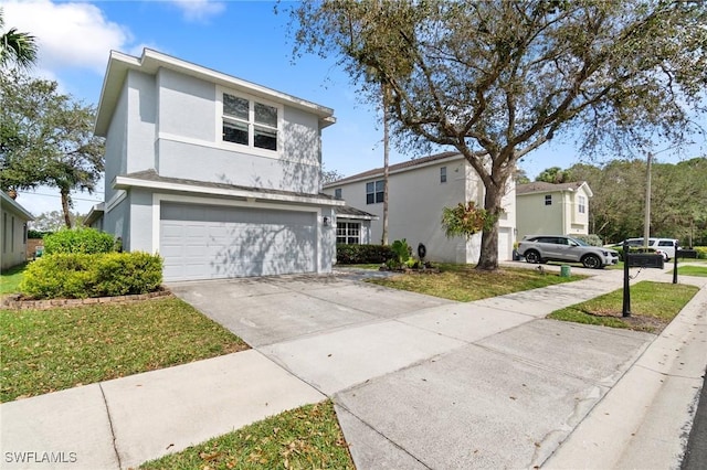 view of front of home featuring a front lawn, driveway, an attached garage, and stucco siding