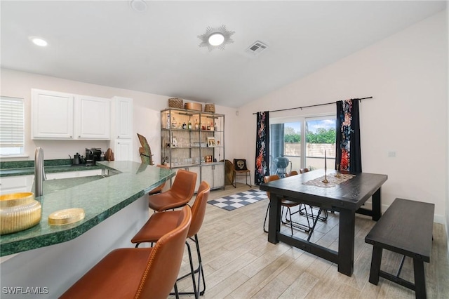 dining area with light wood-style flooring, visible vents, vaulted ceiling, and recessed lighting