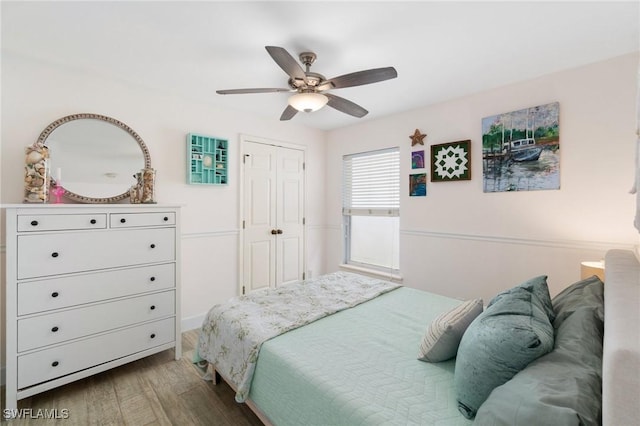 bedroom with a closet, wood finished floors, and a ceiling fan