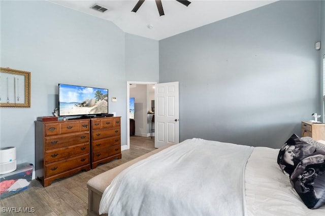 bedroom with ceiling fan, high vaulted ceiling, light wood finished floors, and visible vents