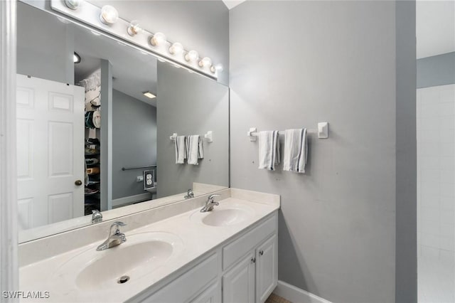 full bathroom with a sink, baseboards, and double vanity