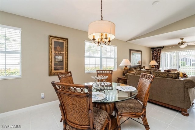 dining area featuring a healthy amount of sunlight, ceiling fan with notable chandelier, light tile patterned flooring, and lofted ceiling