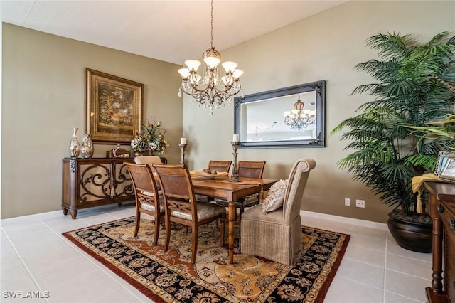 dining space with vaulted ceiling, light tile patterned flooring, a notable chandelier, and baseboards