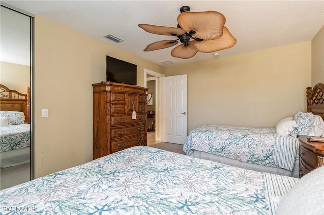 bedroom with a ceiling fan, visible vents, and a closet