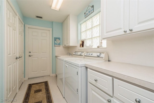 clothes washing area featuring cabinet space, light tile patterned floors, visible vents, and separate washer and dryer