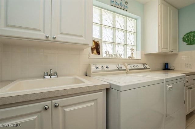 laundry room featuring cabinet space, washer and clothes dryer, and a sink