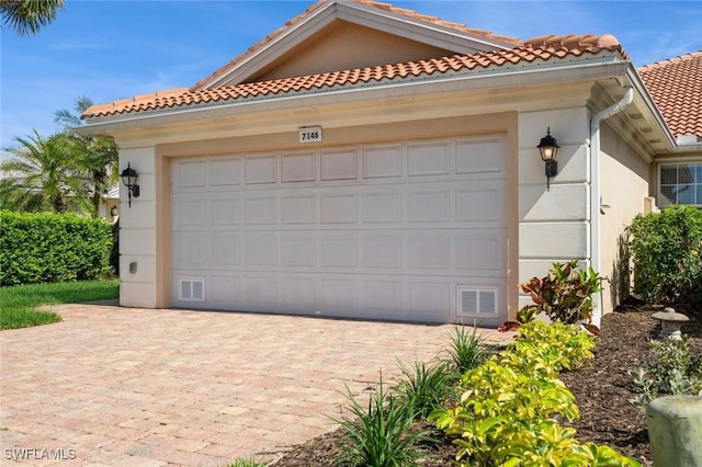 garage with driveway and visible vents