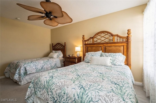 bedroom with ceiling fan, baseboards, and light colored carpet