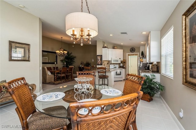 dining space featuring light tile patterned floors, recessed lighting, a notable chandelier, visible vents, and baseboards