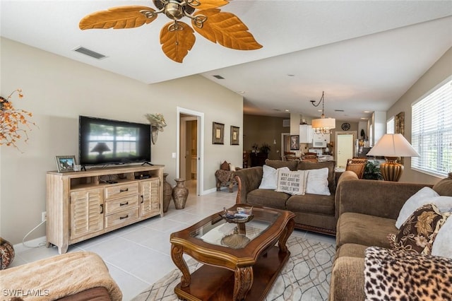 living room featuring light tile patterned floors, ceiling fan, visible vents, and baseboards