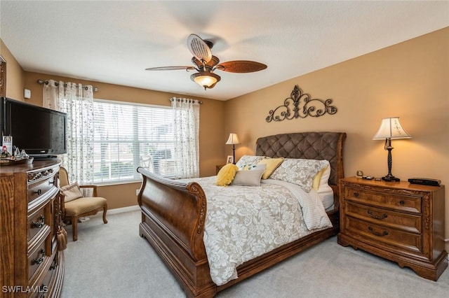 bedroom featuring light carpet, ceiling fan, and baseboards