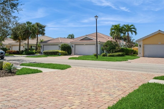 view of front facade featuring stucco siding, decorative driveway, and a tiled roof