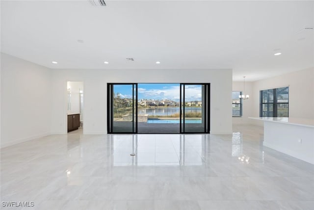 unfurnished room featuring recessed lighting, baseboards, marble finish floor, and an inviting chandelier