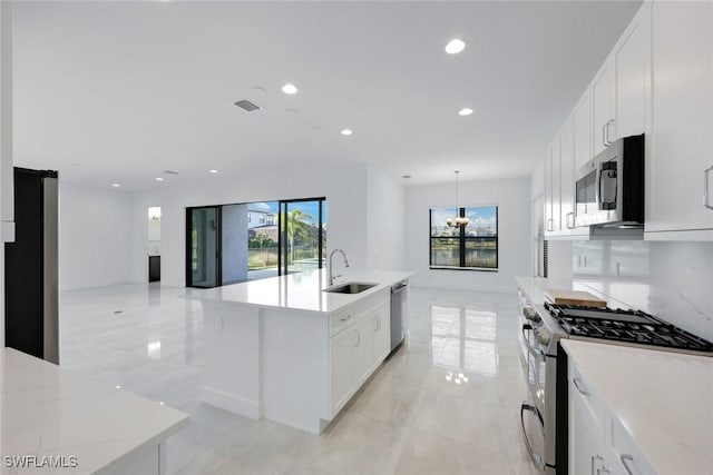 kitchen featuring decorative backsplash, recessed lighting, appliances with stainless steel finishes, white cabinets, and a sink