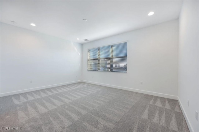 carpeted spare room with recessed lighting, visible vents, and baseboards