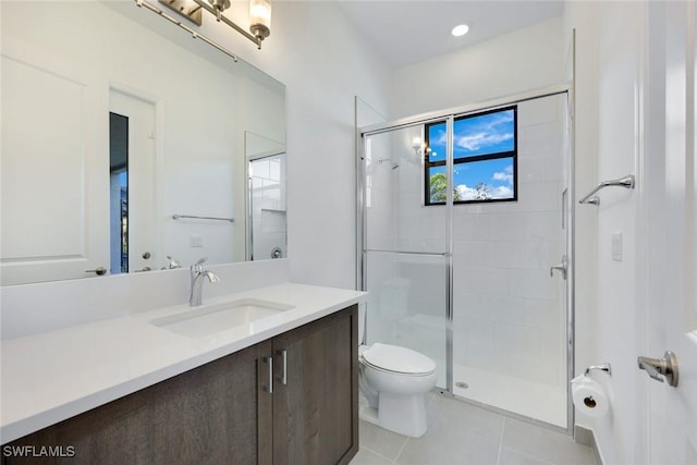 bathroom featuring tile patterned flooring, a shower stall, toilet, and vanity