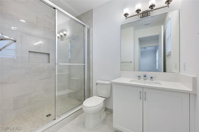 full bath with a shower stall, toilet, vanity, and baseboards