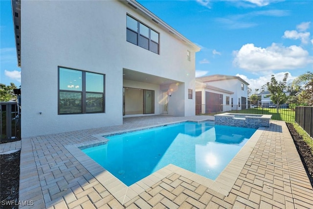 back of house with a patio area, a fenced backyard, a pool with connected hot tub, and stucco siding