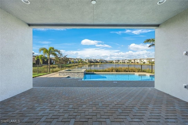 view of pool featuring a fenced in pool, a water view, fence, a patio area, and an in ground hot tub