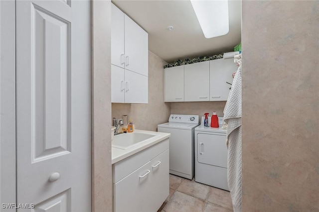 laundry area with separate washer and dryer, light tile patterned flooring, a sink, and cabinet space