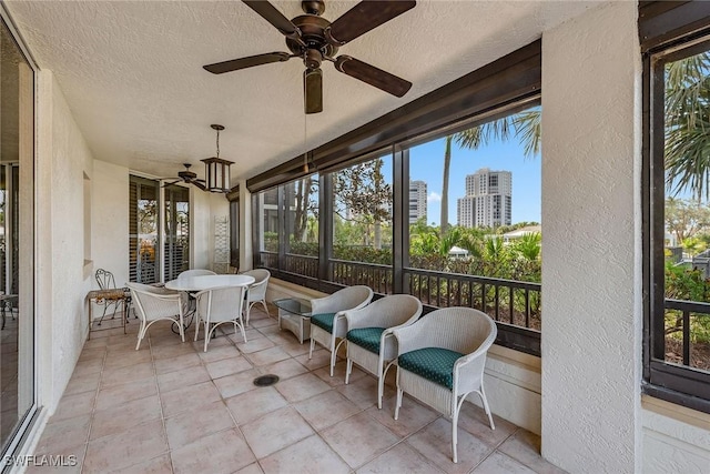 sunroom featuring a city view and ceiling fan