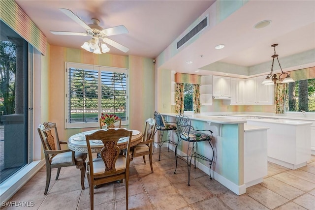 dining room with baseboards, light tile patterned flooring, visible vents, and a ceiling fan