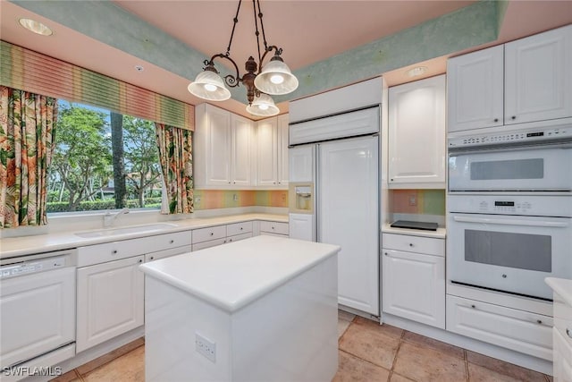 kitchen featuring white appliances, light countertops, white cabinetry, pendant lighting, and a sink