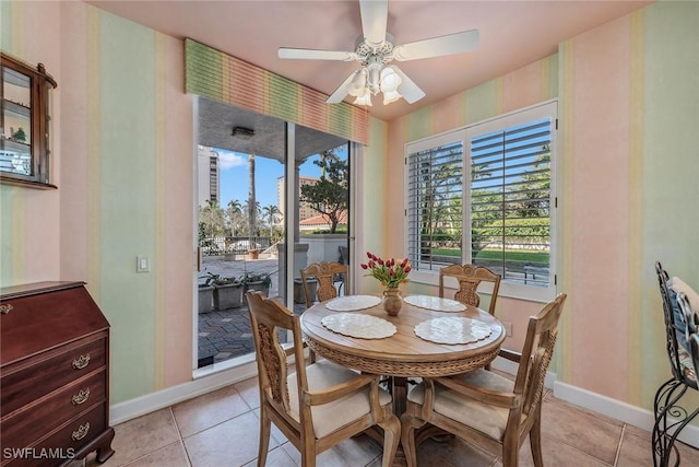 dining area featuring ceiling fan, baseboards, and light tile patterned floors