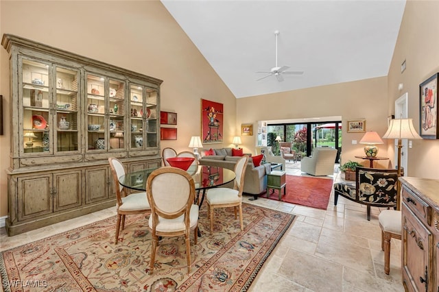 dining room with ceiling fan and high vaulted ceiling