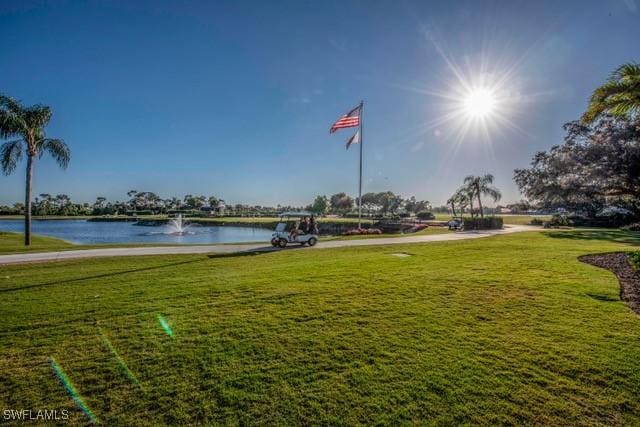 view of property's community with a water view and a yard