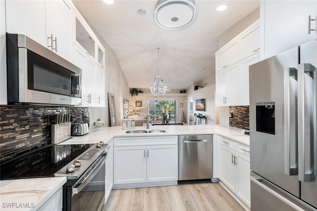 kitchen featuring stainless steel appliances, glass insert cabinets, white cabinets, a sink, and a peninsula