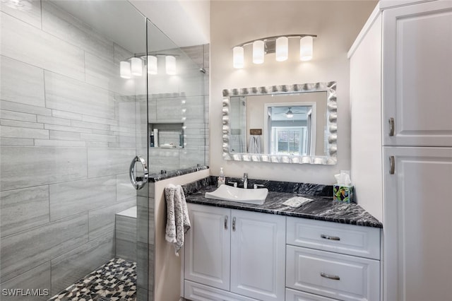 bathroom with tiled shower and vanity