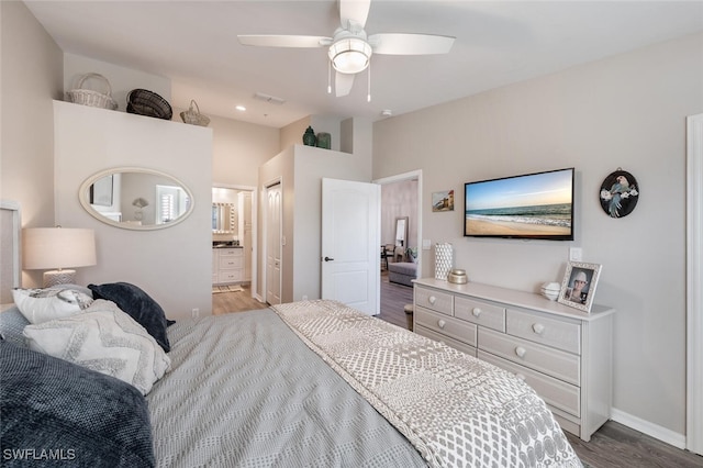 bedroom with baseboards, a ceiling fan, connected bathroom, lofted ceiling, and light wood-type flooring