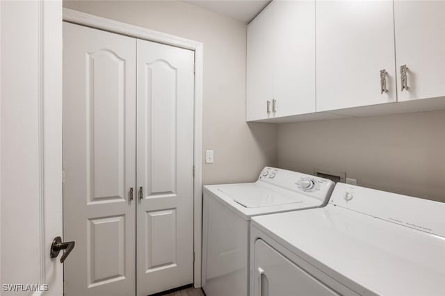 clothes washing area featuring cabinet space and independent washer and dryer