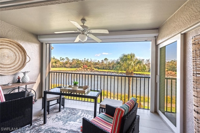 sunroom with a water view, ceiling fan, and a wealth of natural light