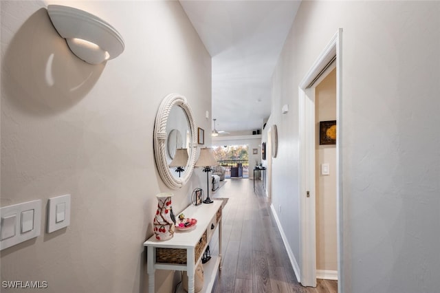 hall featuring baseboards and wood finished floors