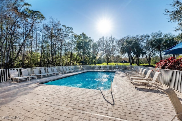 community pool featuring a patio area and fence