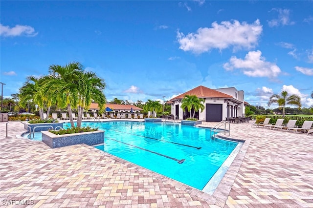 community pool with a patio and fence