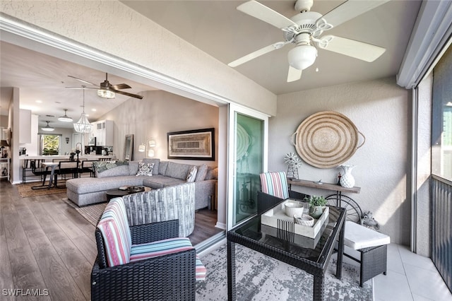 living area featuring lofted ceiling, ceiling fan, and wood finished floors