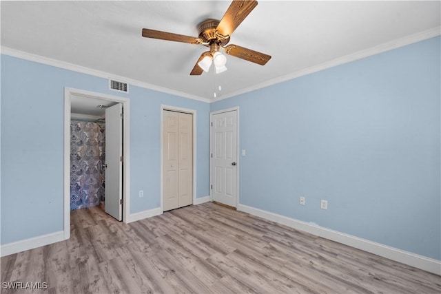 unfurnished bedroom with a ceiling fan, visible vents, wood finished floors, baseboards, and ornamental molding