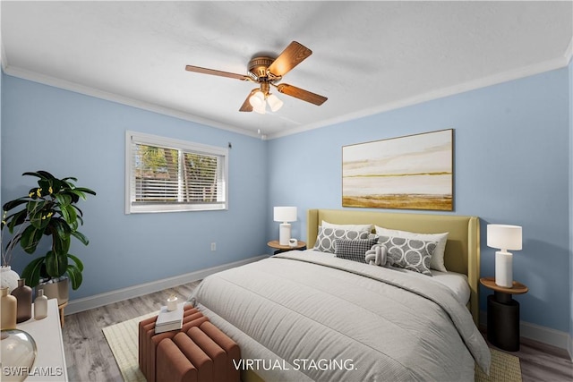 bedroom featuring a ceiling fan, crown molding, baseboards, and wood finished floors