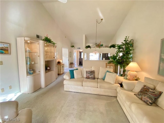 carpeted living area featuring high vaulted ceiling