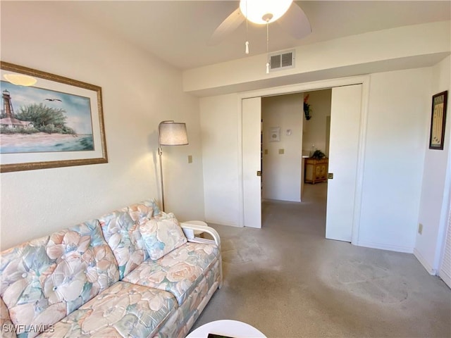 living room featuring a ceiling fan, visible vents, and carpet flooring