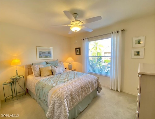 bedroom featuring light carpet, baseboards, and a ceiling fan