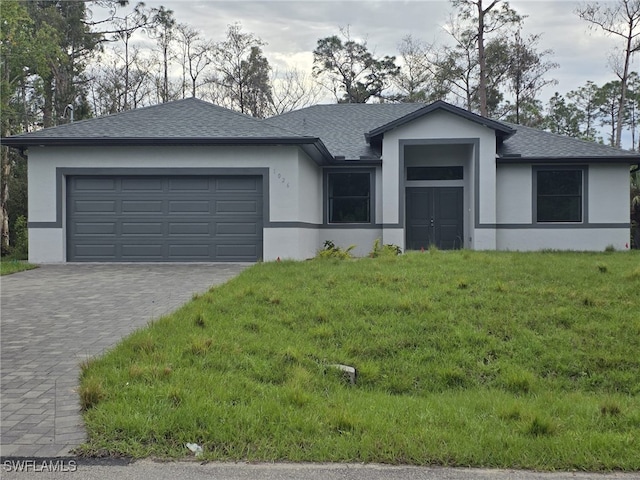 view of front of property featuring decorative driveway, roof with shingles, stucco siding, a garage, and a front lawn