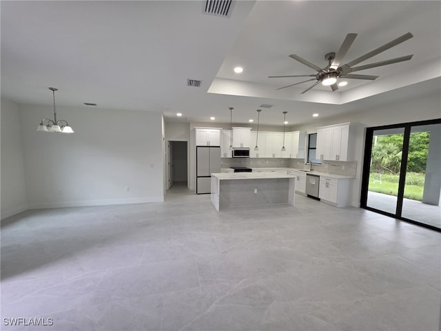 kitchen featuring open floor plan, light countertops, stainless steel appliances, and white cabinets