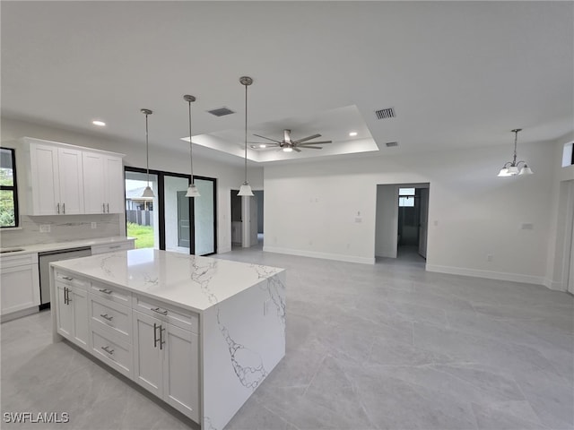 kitchen featuring open floor plan, white cabinetry, a raised ceiling, and stainless steel dishwasher