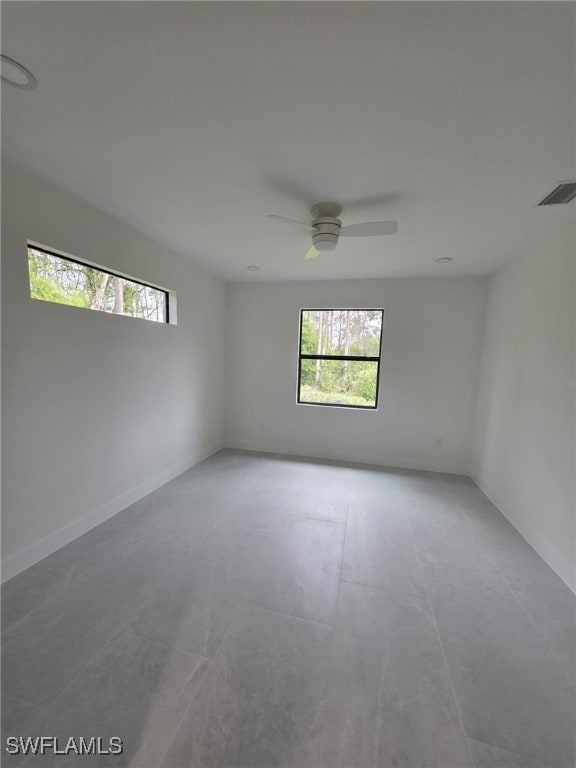 unfurnished room featuring ceiling fan, visible vents, and baseboards