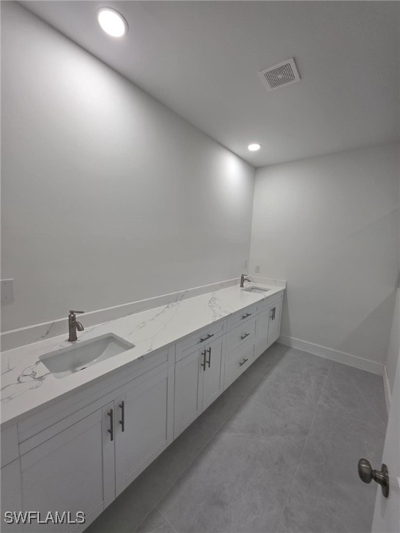 bathroom featuring double vanity, baseboards, visible vents, and a sink