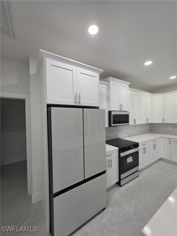 kitchen featuring light countertops, appliances with stainless steel finishes, visible vents, and white cabinets